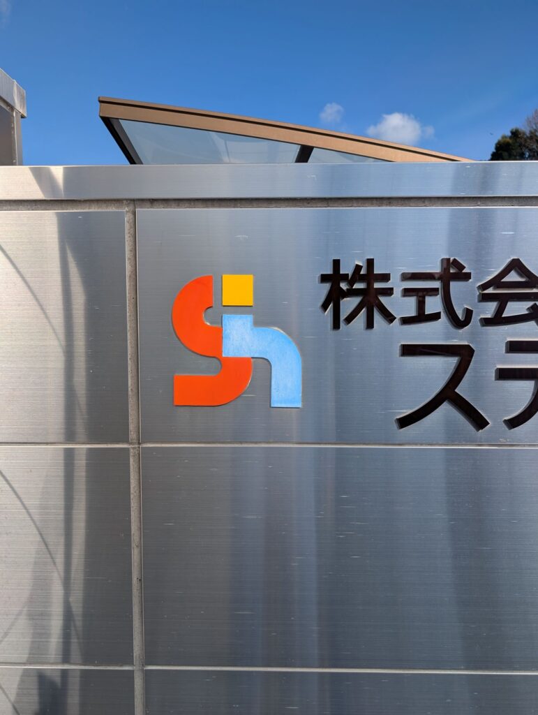 田布施工場門扉正面ロゴ