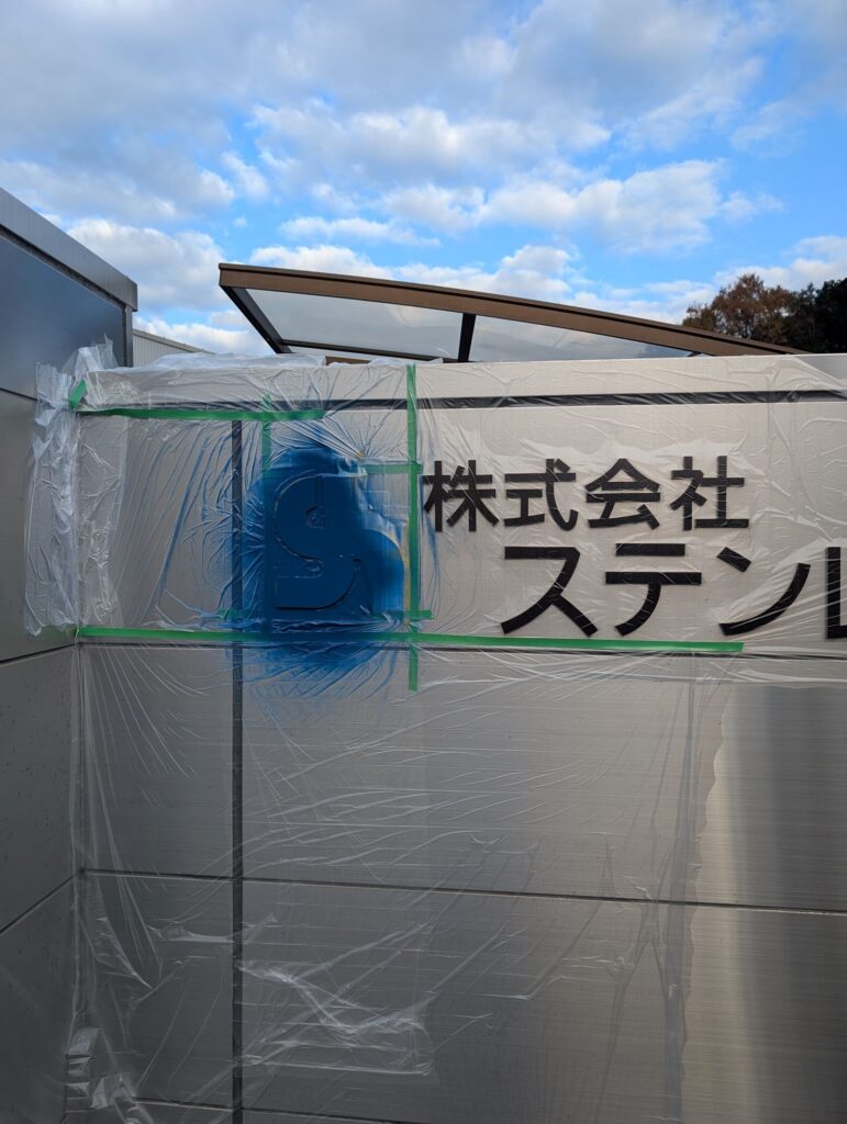 田布施工場門扉正面ロゴ