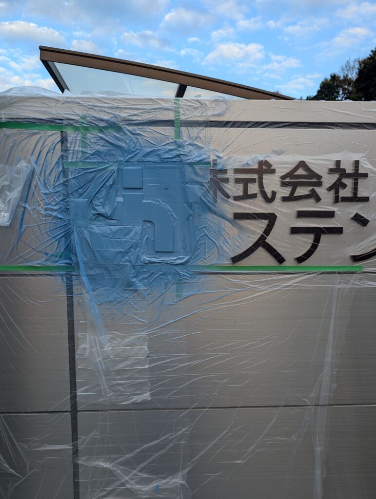 田布施工場門扉正面ロゴ